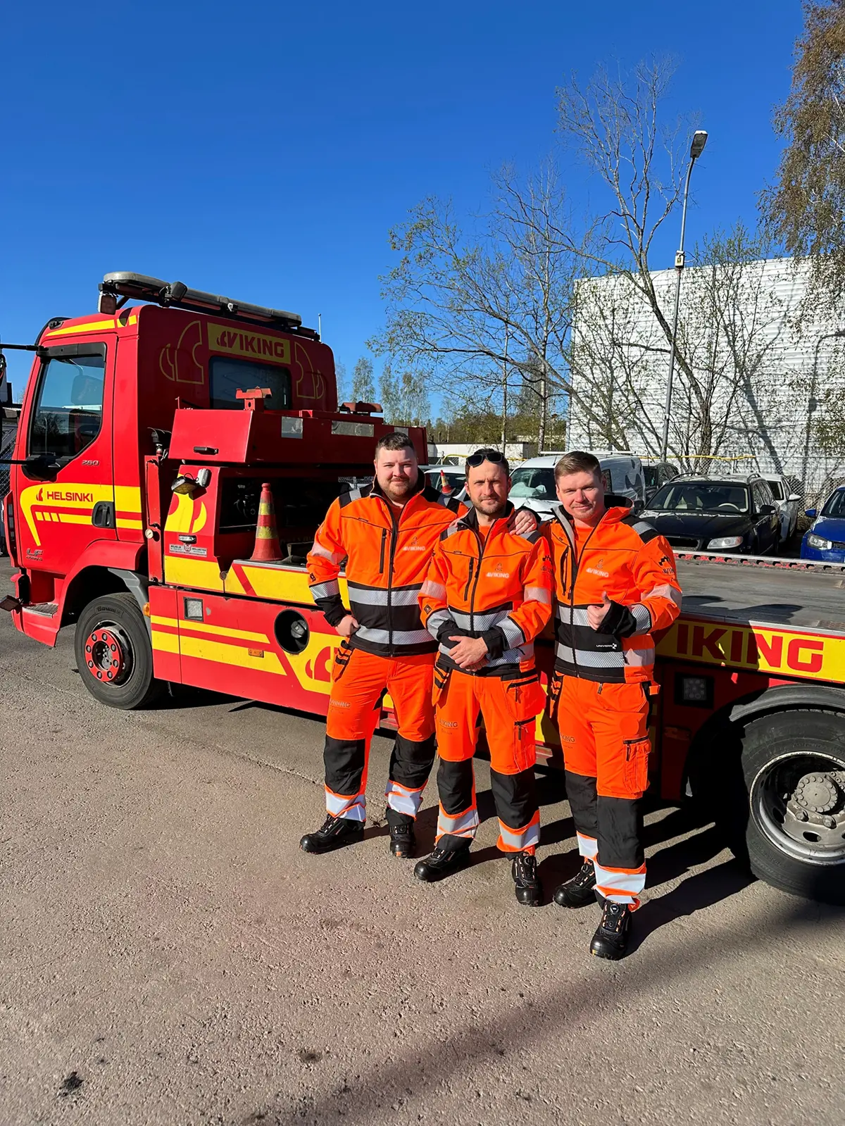 Uudenmaan Tieapu henkilökuntaa rivissä hinausauton edessä.